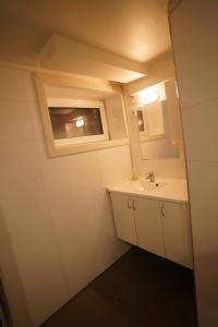 a small bathroom with a sink and a mirror at Comfort Apartment in Tromsø