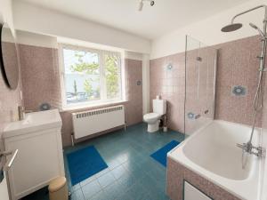 a bathroom with a tub and a toilet and a sink at Modern 2 BR apartment in Centre in Sint-Niklaas
