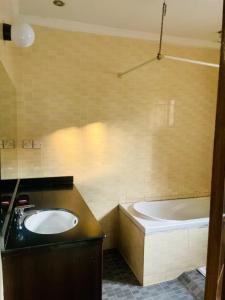 a bathroom with a sink and a bath tub at Gmasters Boutique Hotel in Kigali