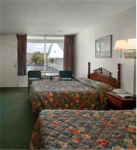 Habitación de hotel con 2 camas y mesa en Travel Inn, en Birmingham