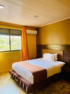 a bedroom with a large bed in a yellow room at Gmasters Boutique Hotel in Kigali