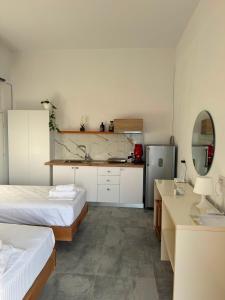 ein Zimmer mit zwei Betten und einer Küche in der Unterkunft Solemare in Himarë