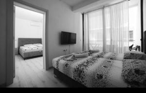 a bedroom with two beds and a large window at Cozy Apartments in Ulcinj