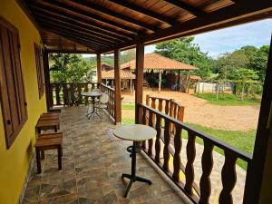 a balcony of a house with tables and chairs at Recanto do Sitio in Tiradentes