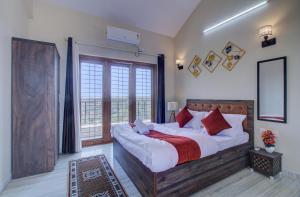 a bedroom with a large bed and a large window at TAJ VILLA Mahabaleshwar in Mahabaleshwar +43 photos
