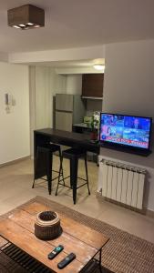 a living room with a black table and a flat screen tv at Ventanas A LA CIUDAD in Mar del Plata +1 photo