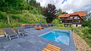 a backyard with a swimming pool and a house at Bergidylle Winkler in Steindorf am Ossiacher See