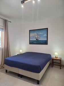 a bedroom with a blue bed in a room at Villetta Lu Sule in Porto Cesareo