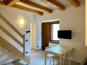 a dining room with a table and a tv at Piazza Maggiore Charming Apartament in Santa Maria Maggiore