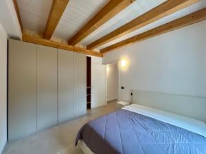 a bedroom with a bed and a wooden ceiling at Piazza Maggiore Charming Apartament in Santa Maria Maggiore
