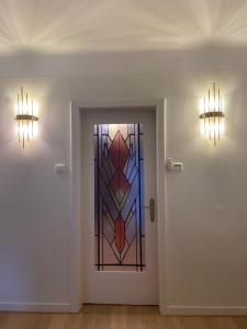 a hallway with a door with a stained glass window at Cosy Carré in Sélestat