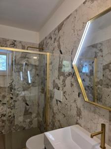 a bathroom with a shower and a sink and a mirror at Villetta Lu Sule in Porto Cesareo +42 photos