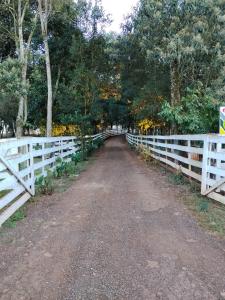 a dirt road next to a white fence at Hotel do Catarina in Rio Bonito +4 photos