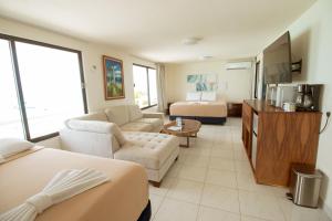 a hotel room with two beds and a living room at Charly Beach Hotel in Isla Mujeres