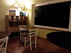 a dining room with a large television and tables and chairs at Il Rifugio in Franciacorta in Erbusco