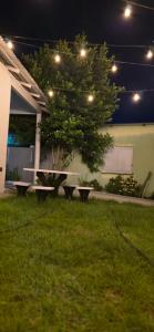 a table and benches in a yard at night at Mecejana Home in Boa Vista