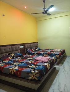 two beds in a room with yellow walls at Hotel sawariya in Godarpura +3 photos