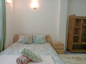 a bedroom with a bed with pillows on it at Stupas, Temples and Coffee 2BR Flat in Kathmandu in Kathmandu