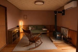 a living room with a couch and a chair at Secret Beach House MOKU in Fukutsu