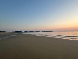 a view of the beach at sunset at Secret Beach House MOKU in Fukutsu