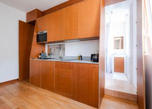 a kitchen with wooden cabinets and a sink at Studio Design Paris 20 min RER A in Nogent-sur-Marne