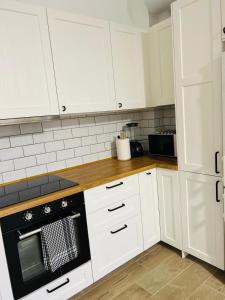 a kitchen with white cabinets and a black oven at Chalet con piscina en Carmona in Carmona