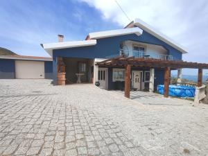 a blue house with a stone driveway in front of it at Casa da Susy do Alvão in Vila Real