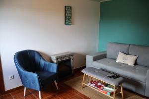 a living room with a couch and a chair at Casa das Brisas Matinais in Conceição +17 photos