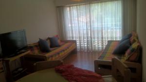 a living room with a couch and a tv at Arco Iris in Miramar