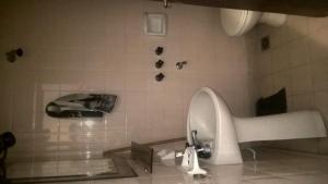 a bathroom with a sink and a tiled wall at Arco Iris in Miramar +6 photos