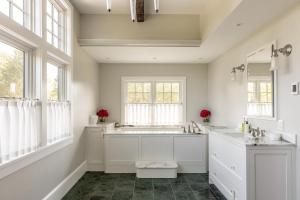 a white bathroom with two sinks and windows at Greycliff Mohonk Preserve Getaway in New Paltz +39 photos