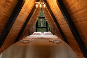 a bed in a room with a window at Durmitor forest lodge in Žabljak +40 photos