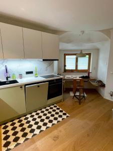 a kitchen with white cabinets and a table and a counter at Kaiserblick Lodge Oberaudorf in Oberaudorf