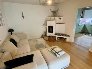a living room with a white couch and a fireplace at Kaiserblick Lodge Oberaudorf in Oberaudorf
