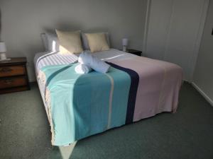a bed with two stuffed animals sitting on top of it at Handy to Town, Spacious, Relaxed - KK14905 in Kaikoura