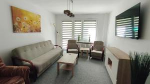 a living room with a couch and chairs and a table at Przy Głównej in Zamość