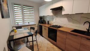 a kitchen with a table and a stove top oven at Przy Głównej in Zamość +3 photos