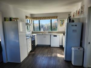 a kitchen with a white refrigerator and a window at Handy to Town, Spacious, Relaxed - KK14905 in Kaikoura