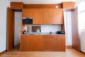 a kitchen with wooden cabinets and a sink at Studio Design Paris 20 min RER A in Nogent-sur-Marne