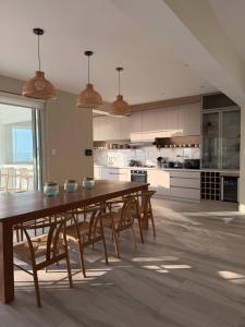 a large kitchen with a wooden table and chairs at Casa Marena Punta Sal in La Bocana