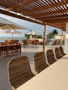 a group of chairs and tables and umbrellas on the beach at Casa Marena Punta Sal in La Bocana