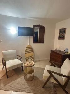 a living room with a chair and a table at studio Sainte Anne 2mn a pieds de la plage in Sainte-Anne