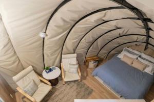 an overhead view of a tent with a bed and chairs at Fenlea Resort Glamping Cocoon in Hampton +25 photos