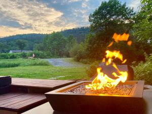 a fire pit on a table with a view of a field at Fenlea Resort Glamping Cocoon in Hampton