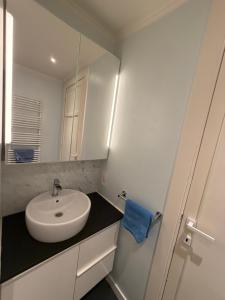 a white bathroom with a sink and a mirror at Res. Golf Zoute in Knokke-Heist +14 photos