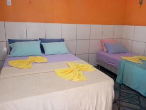 two beds with towels on top of them in a room at Pousada Açaí in Salvaterra