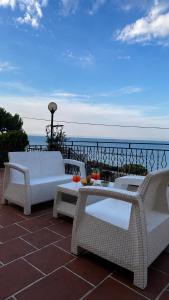 a patio with white chairs and a table and the ocean at Villa sul mare di Cupra in Cupra Marittima