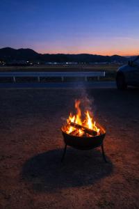 a fire pit sitting in the dirt at night at Secret Beach House MOKU in Fukutsu