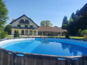 a large swimming pool in front of a house at Pensiunea VALEA LISEI in Lissa