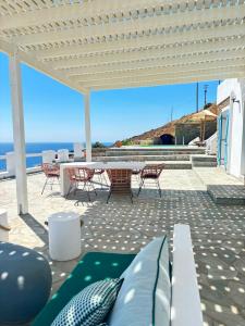 a patio with a table and chairs and the ocean at Villa de Estrella in Agios Dimitrios